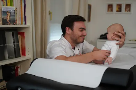Nicolas Huet traitant un nourrisson sur la table d'ostéopathie